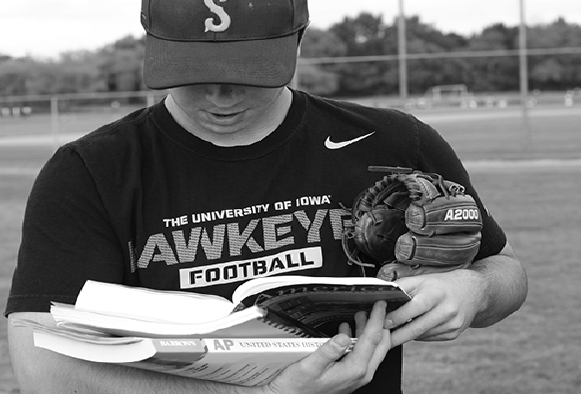 STOPPING STEREOTYPES. Picking up books on the field, Justin Stark ’16 breaks the social stereotype of athletes. Stark balances his sports and academics on and off the field.