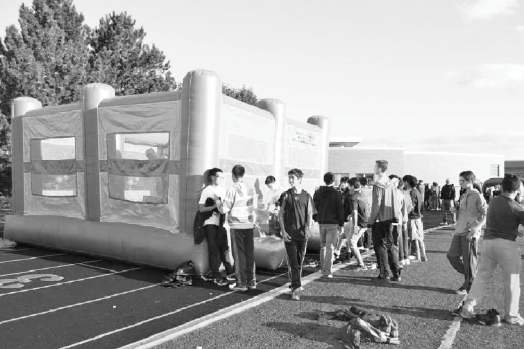 Students get in line outside inflatables set up on the football field for Spirit Fest.