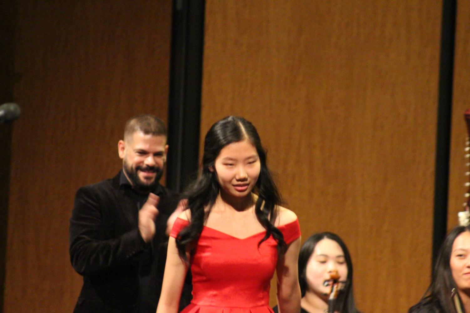 Senior Soloist Stephanie Li '19 walks up to the piano before her solo as Enrique Vilaseco cheers her on. Li went on to perform Ravel's Piano Concerto in G Major, Movement No. 1.