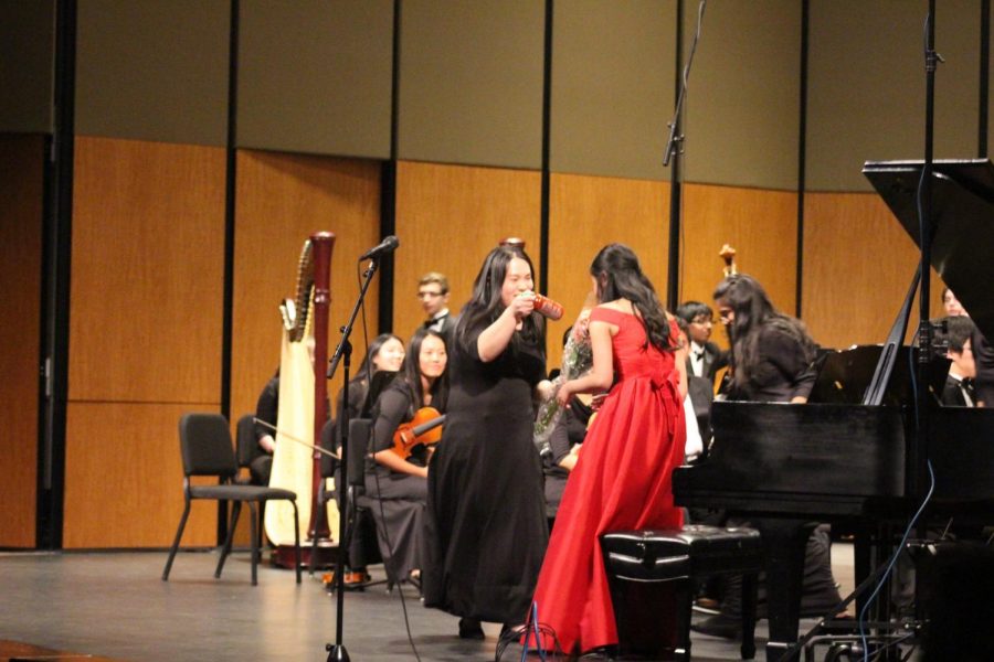 Julie Zhu 19 presents Stephanie Li 19 with a bottle of Sriracha. Li was the senior soloist for the concert.