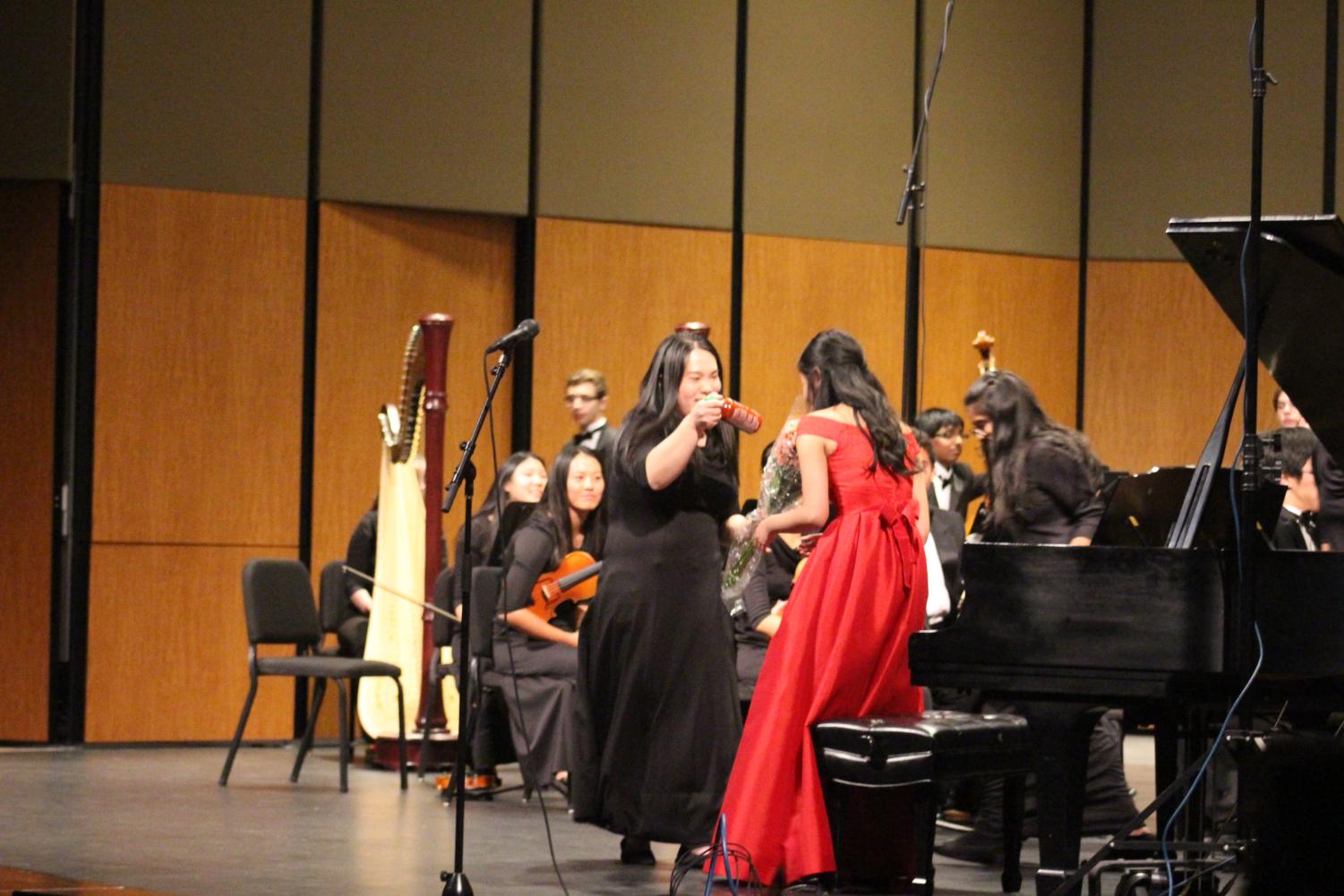 Julie Zhu '19 presents Stephanie Li '19 with a bottle of Sriracha. Li was the senior soloist for the concert.