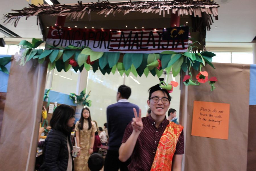 Dylan Chae 20, President of Diversity Council, posed by the entrance to the Singapore and Malaysian booths.  Chae is dressed in traditional Malay clothing.