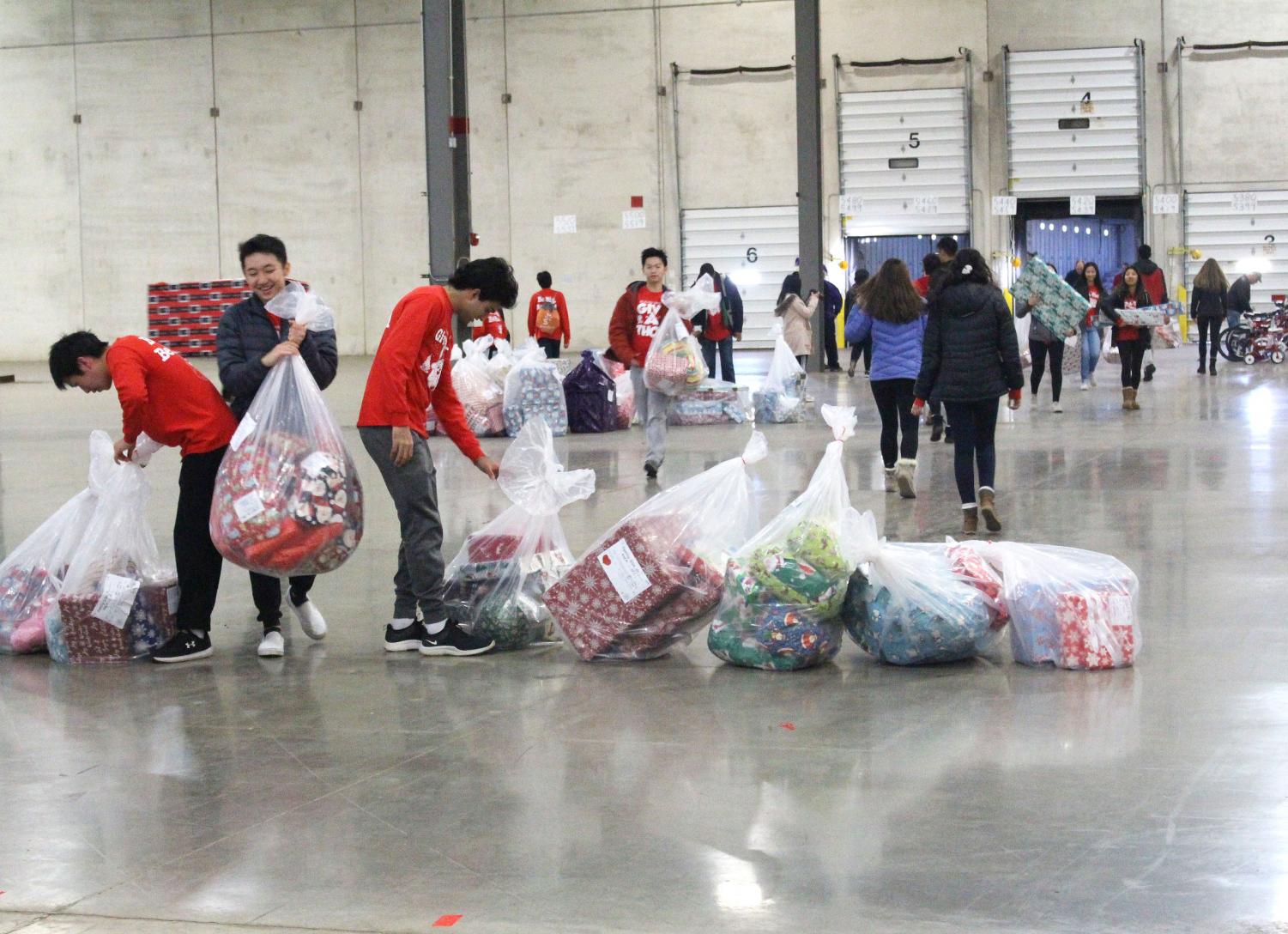 Volunteers line up bags of labeled gifts. Catholic Charities warehouse receives gifts from multiple families and organizations in Lake County to be donated to low income families in the area.