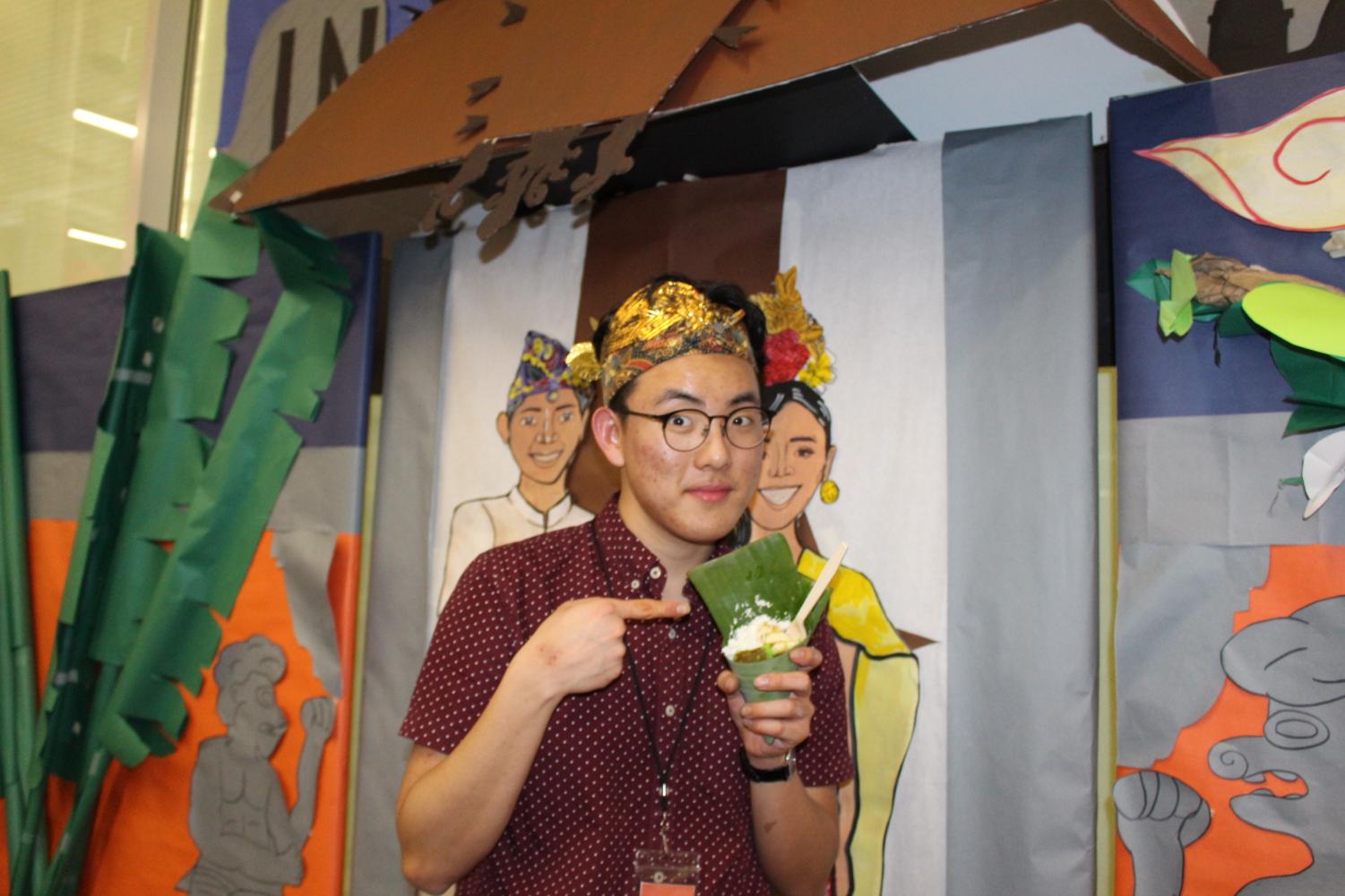 Dylan Chae '20 serves Jajan Pansa, a Javnese market snack, wrapped in banana leaves and topped with coconut shaving as well as banana slices.