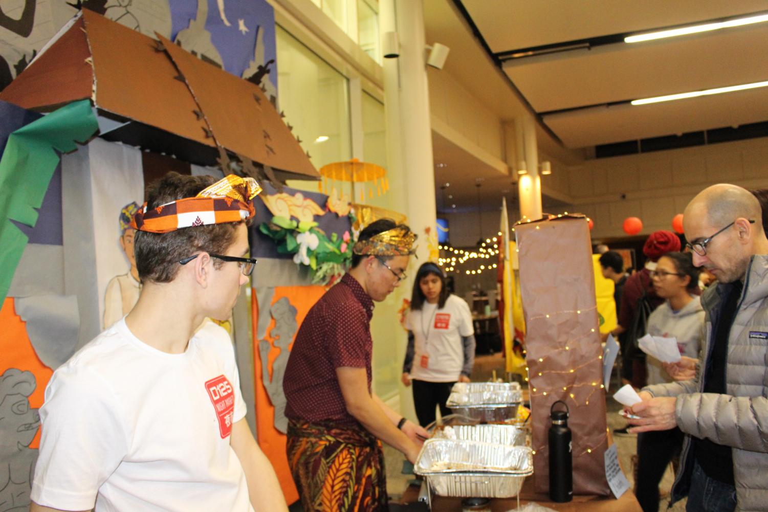 Dylan Chae '20 serves Sate Ayam Betawi to people.