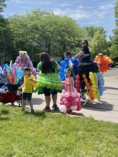 Members of Face Paint with a Twist put the finishing touches on their balloon gowns. They handed out bracelets to match different pride flags as well as balloon art to parade goers.