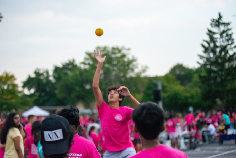 A Streetfest attendee reaches into the air to hit the Spikeball back onto the net. The student joined three friends in one of the many games offered at Streetfest that intended to celebrate wellness.