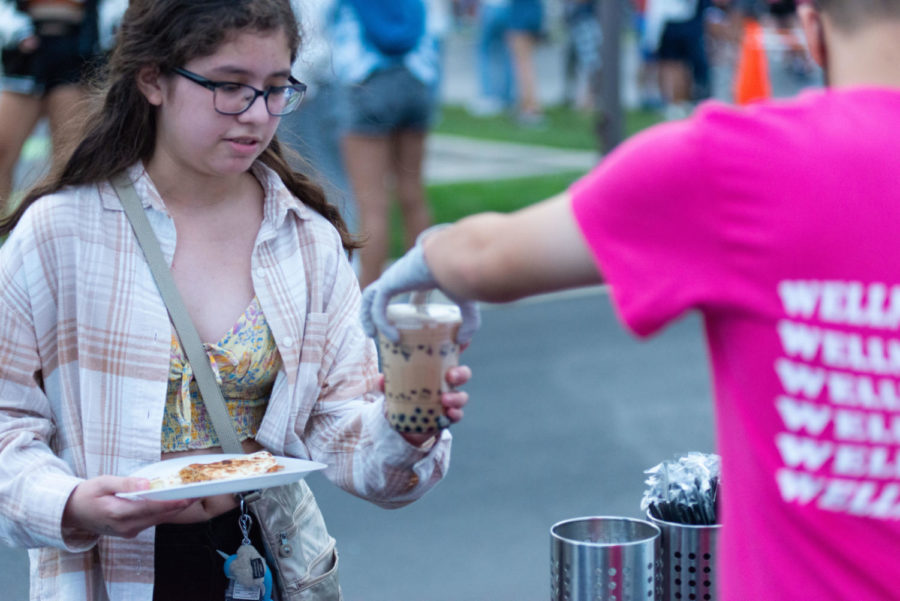 A Bearology booth manager hands a cup of boba tea to a student at Streetfest. Among other food truck options like shaved ice, gyros, pizza and tacos, Bearology’s boba tea was a student favorite.