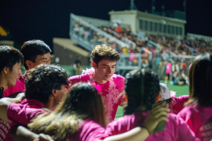 NHS Executive Board members huddle together prior to kicking off the Streetfest performances as attendees fill the bleachers. The leadership team planned for weeks to organize the highly-attended event.