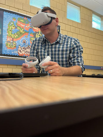 Course developer Michael Anderson demonstrates a VR headset similar to what students will use in the course. Students will have the option to register for the course during course selection in the coming months.
