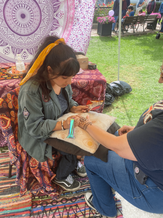 A festival goer receives a henna tattoo at owner Susy Garcia’s decorated Henna booth. This activity taught visitors more about the 5000-year-old Pakistani, Indian, African and Middle Eastern henna practice.