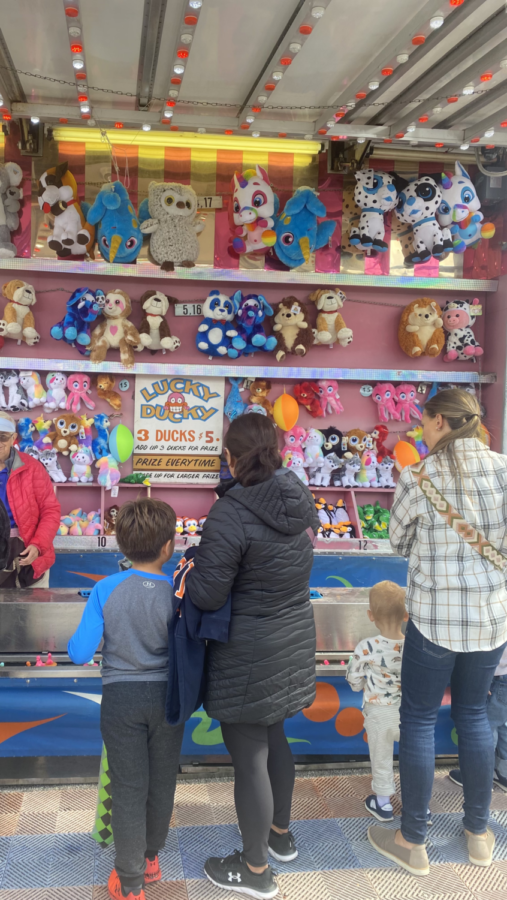 Families gather around the “Lucky Ducky” game booth to try their hand at winning a stuffed animal. Games at Apple Fest allowed for engagement among all age groups. Some of the most popular activities in the event included a pie-eating contest and an arts and crafts activity in the Kid Zone.