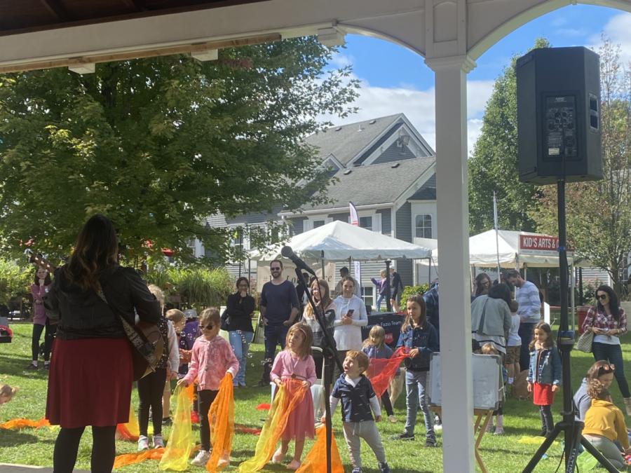 A group of kids gaze up at a singing entertainer during a game of freeze dance. Local musicians and artists helped keep a family-oriented atmosphere which was one of the core visions of the Apple Fest event.
