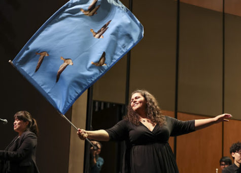 Band executive board member Ali Murillo ’23 waves a goose flag during the 2022 Fall Band concert. The flag represents tradition and community within Symphonic Band. Photo courtesy of Stevenson’s SmugMug.