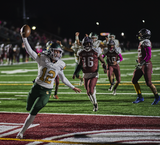 Backup quarterback Ben Fawcett ’24 holds the ball in the air as he scrambles into the endzone in the fourth quarter. Fawcett is the first junior to score a touchdown this season.