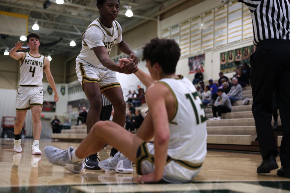 Armand Burris ’24 helping up Jack Dabbs ’24 after a foul. The seniors were instrumental in their win, combining for 35 points.