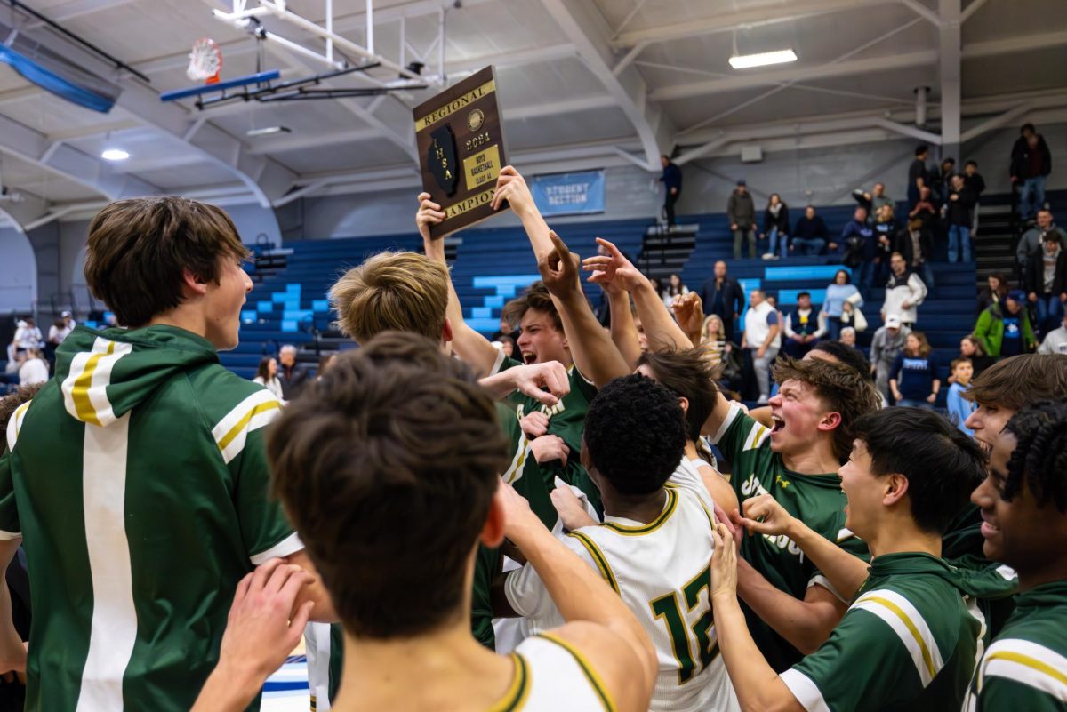 The Patriots basketball team hoists the Regional Championship plaque high after the victory. This is the second consecutive season the Patriots have won the Regional Championship.