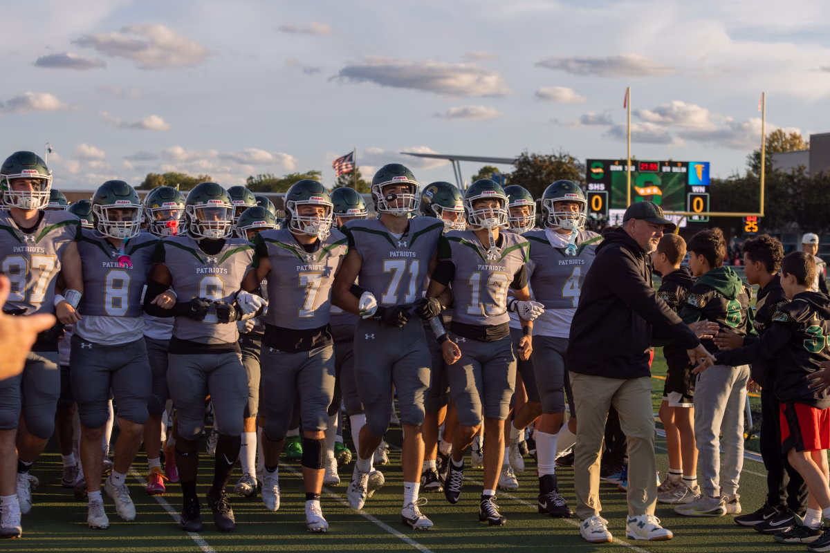 Stevenson’s Varsity Football Team walks down the track for the Night of Champions, transitioning to their pre-game warm up. Other Stevenson varsity sports teams followed behind them.