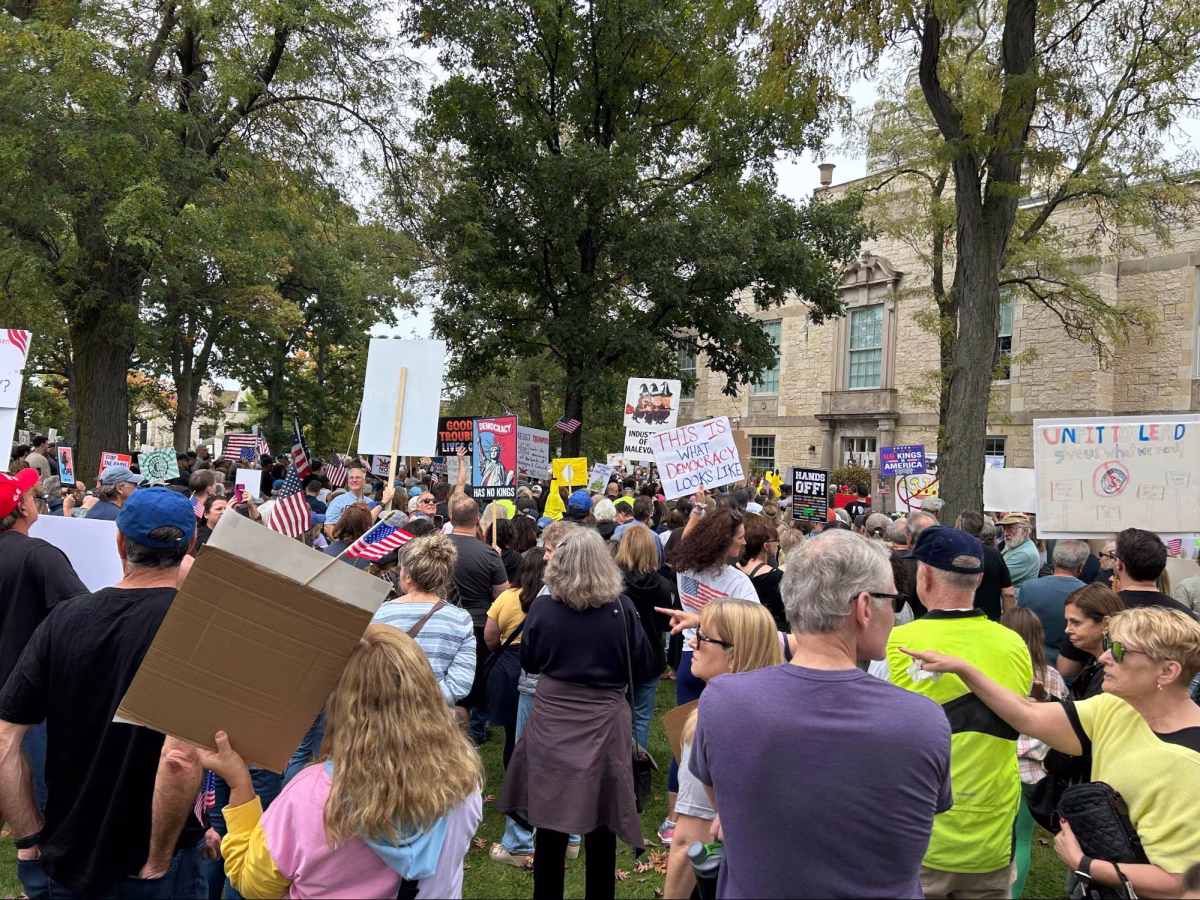Protesters raise their signs high during the “No Kings” protest in Highland Park on Oct. 18. According to Britannica, roughly 7 million people attended “No Kings” protests across the nation.