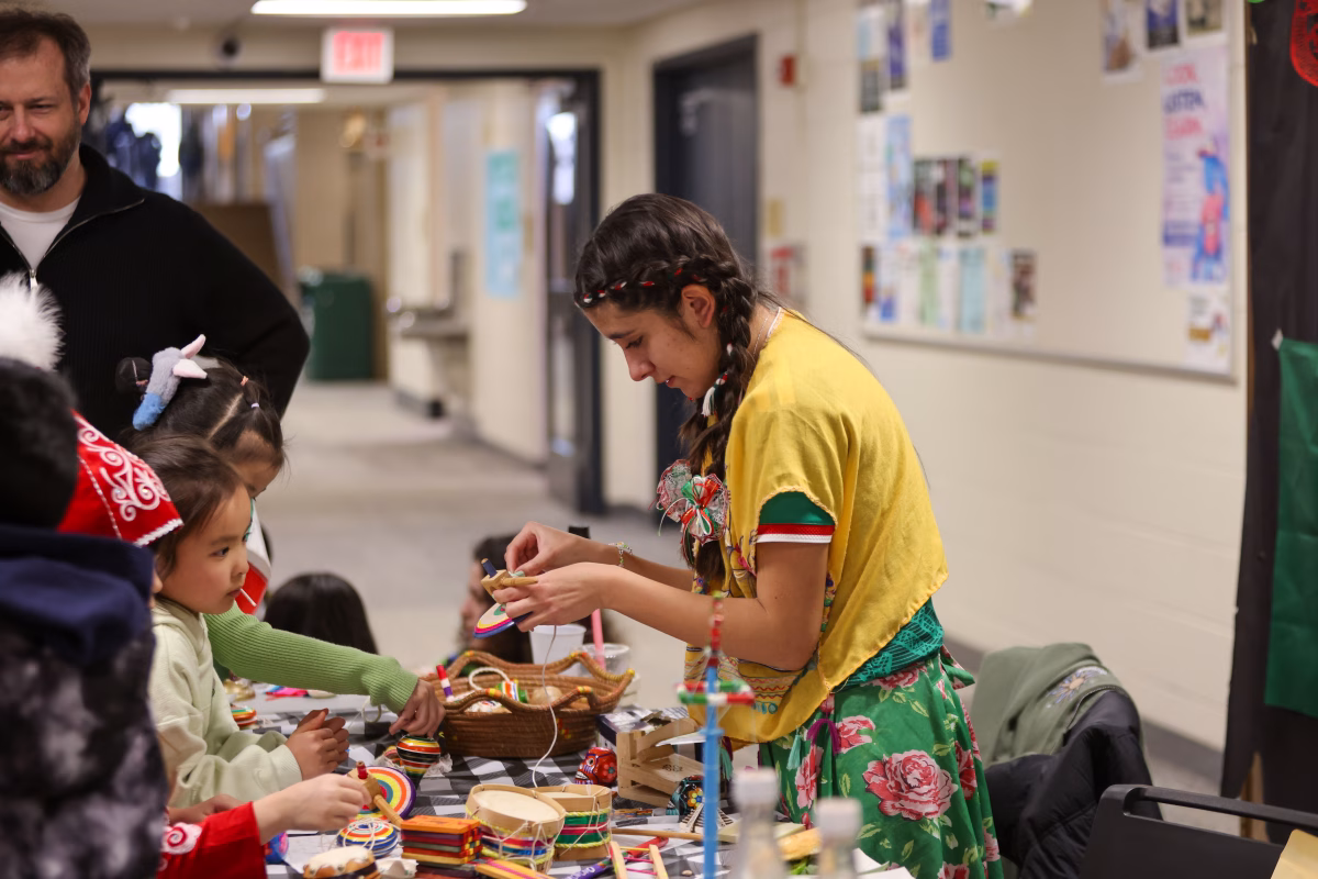 Visitors at Latin American Student Organization’s (LASO) booth take a look at various cultural items. Many other booths also feature various interactive displays of their culture, such as games.